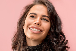Headshot of a smiling young woman with clear braces