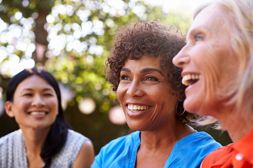 A group of smiling older women with dental implants from Matsui Dental in New York, NY
